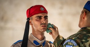 A soldier wipes the sweat from the face of a Greek Presidential Guard (Evzonas) as he stands guard at the Tomb of the Unknown Soldier, Athens, Greece, July 21, 2026. (AFP Photo)