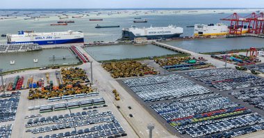 Three specialized car transport ships are seen behind rows of cars waiting to be loaded at Suzhou port, eastern Jiangsu province, China, Sept. 9, 2026. (AFP Photo)