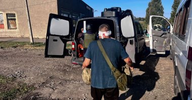 Ukrainian rescuers help passengers of a regular intercity minibus damaged following a Russian drone strike in the Nikopol district of Dnipropetrovsk region, Ukraine, Sept. 16, 2026. (AFP Photo)