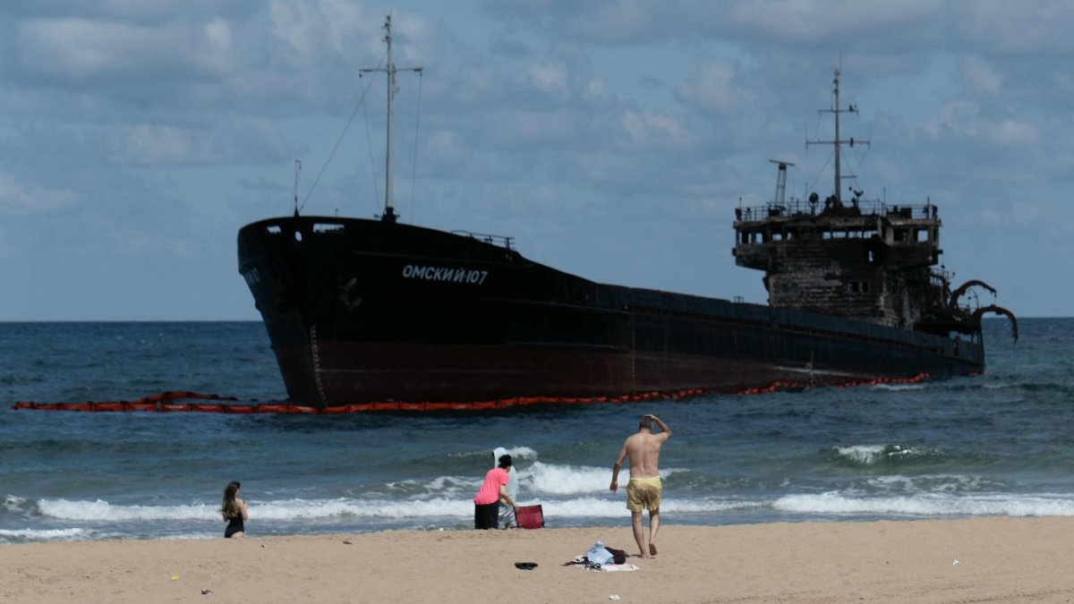 People swim next to the Russian-flagged cargo ship OMSKIY-107, which was attacked off the coast of Russia, drifted and ran aground off the shore of the Şile district, Istanbul, Türkiye, Sept. 3, 2026. (AFP Photo)
