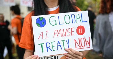 A woman holds a placard during an "emergency protest" by civic action group PauseAI UK outside Downing Street, central London, U.K., Sept. 16, 2026. (AFP Photo)