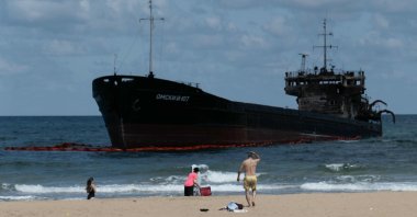 People swim next to the Russian-flagged cargo ship OMSKIY-107, which was attacked off the coast of Russia, drifted and ran aground off the shore of the Şile district, Istanbul, Türkiye, Sept. 3, 2026. (AFP Photo)
