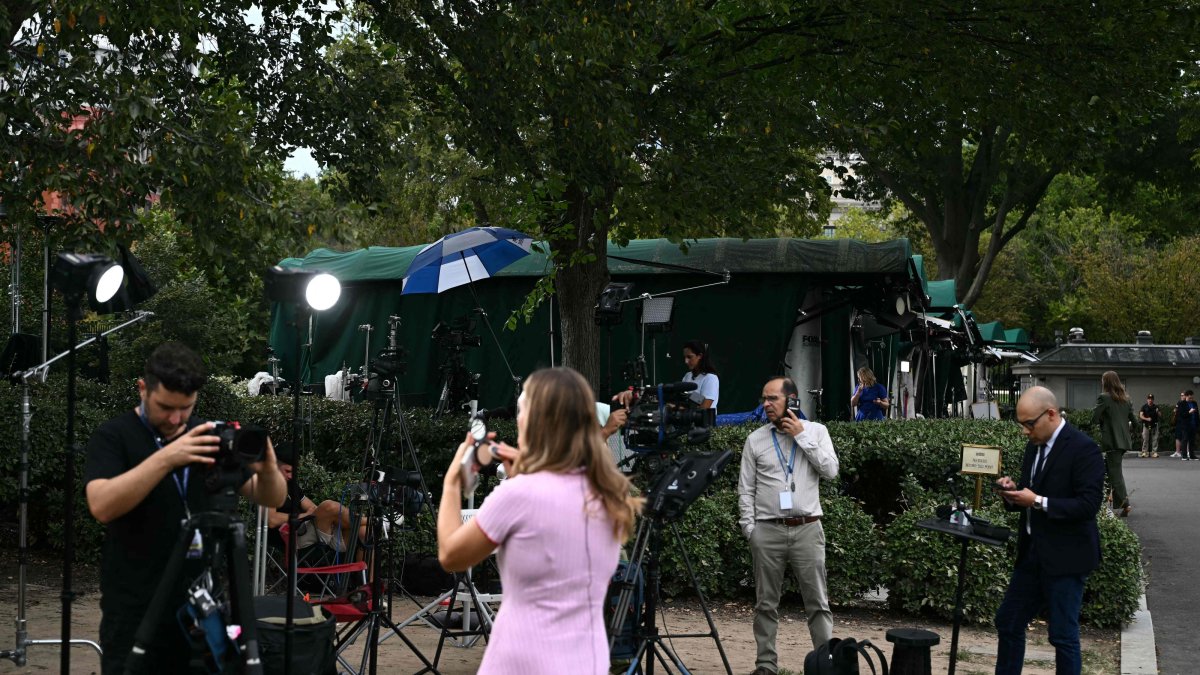 Members of the media on Pebble Beach, where television networks broadcast from the North Lawn of the White House, in Washington, DC, Sept. 18, 2026. (AFP Photo)