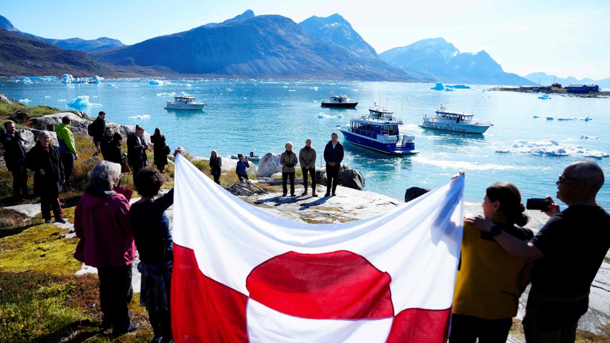 Bystanders display a flag of Greenland as European Commission President Ursula von der Leyen (back L), Greenland's Prime Minister Jens-Frederik Nielsen (back R) and Denmark's Prime Minister Mette Frederiksen visit Qoornoq, Greenland, Sept. 6, 2026. (AFP Photo)