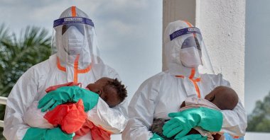DRC medical workers dressed in personal protective equipment (PPE) carry children tested and cleared of Ebola from Saint Nicholas Orphanage, Bunia, DRC, June 9, 2026. (Reuters Photo)
