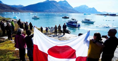 Bystanders display a flag of Greenland as European Commission President Ursula von der Leyen (back L), Greenland's Prime Minister Jens-Frederik Nielsen (back R) and Denmark's Prime Minister Mette Frederiksen visit Qoornoq, Greenland, Sept. 6, 2026. (AFP Photo)