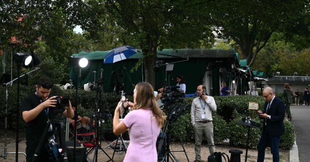 Members of the media on Pebble Beach, where television networks broadcast from the North Lawn of the White House, in Washington, DC, Sept. 18, 2026. (AFP Photo)