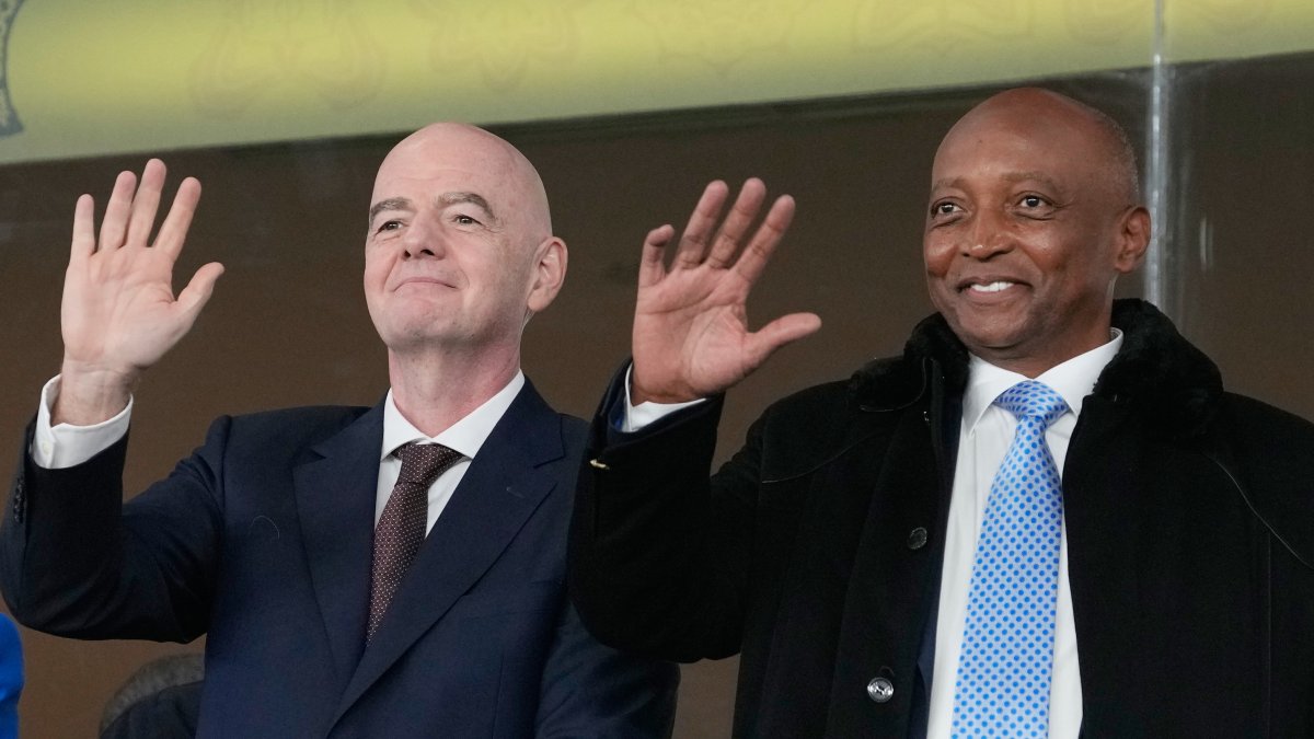 CAF President Patrice Motsepe (R) and FIFA President Gianni Infantino wave from the tribune during the Africa Cup of Nations round of 16 match between South Africa and Cameroon, Rabat, Morocco, Jan. 4, 2026. (AP Photo)