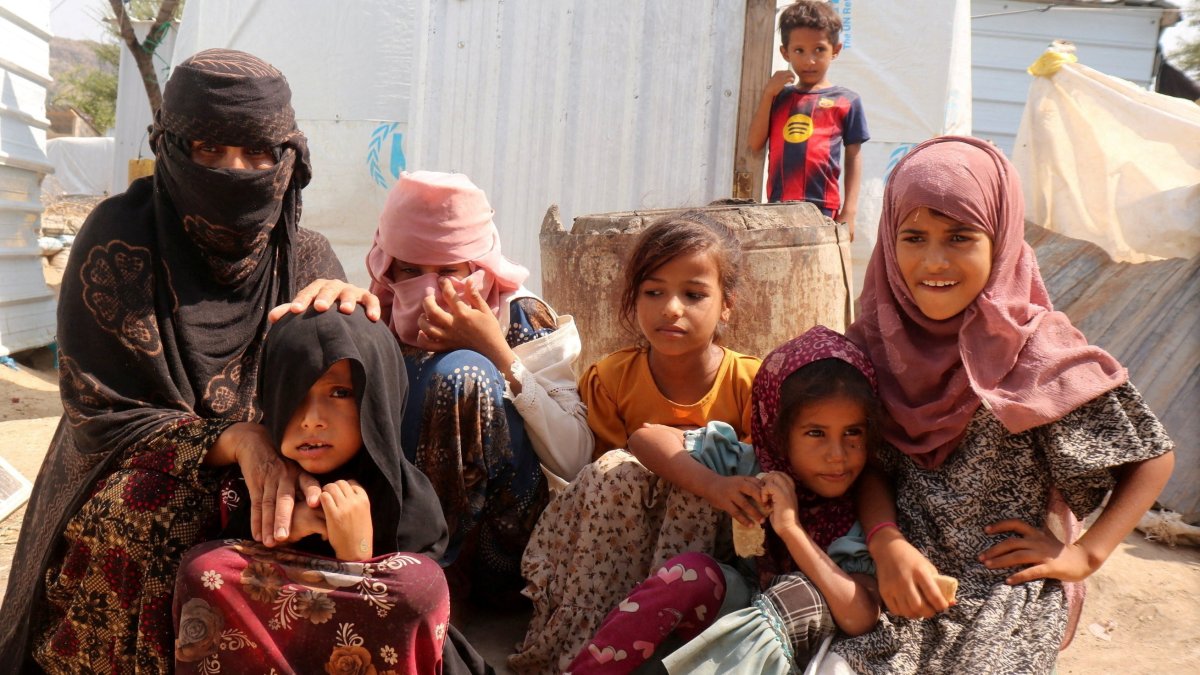 Rawya Hassan, a mother of seven, sits with her children outside their hut at the al-Bireen camp for displaced people who fled fighting between the Houthis and forces of Yemen's internationally recognized government, Taiz province, Yemen, Sept. 17, 2026. (Reuters Photo)