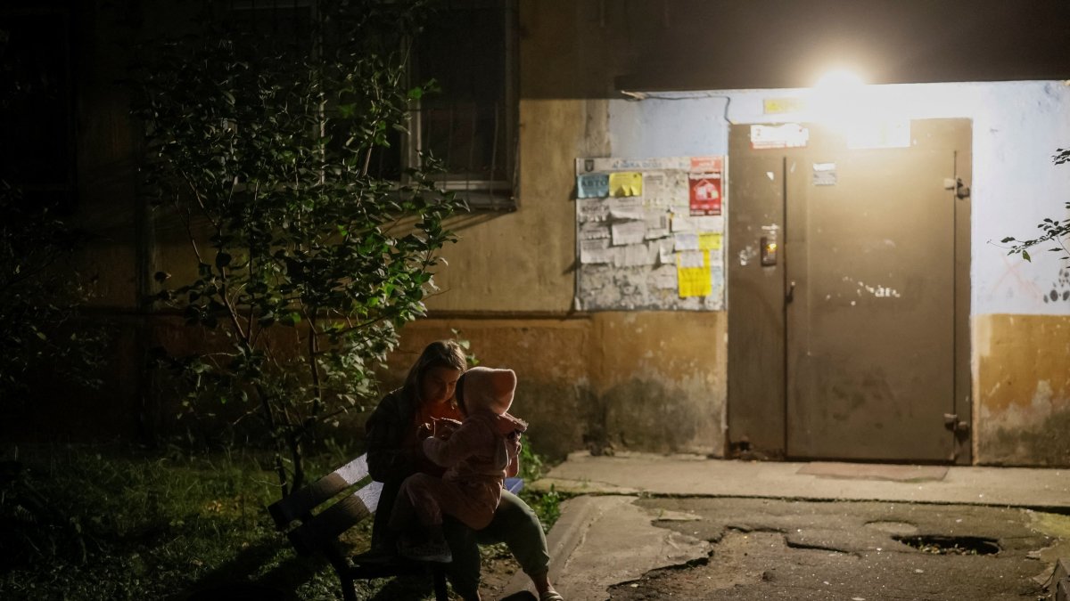 A woman with her daughter sits at the site of an apartment building hit by a Russian drone strike, amid Russia's attack on Ukraine, Kyiv, Ukraine, Sept. 11, 2026. (Reuters Photo)