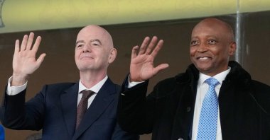 CAF President Patrice Motsepe (R) and FIFA President Gianni Infantino wave from the tribune during the Africa Cup of Nations round of 16 match between South Africa and Cameroon, Rabat, Morocco, Jan. 4, 2026. (AP Photo)