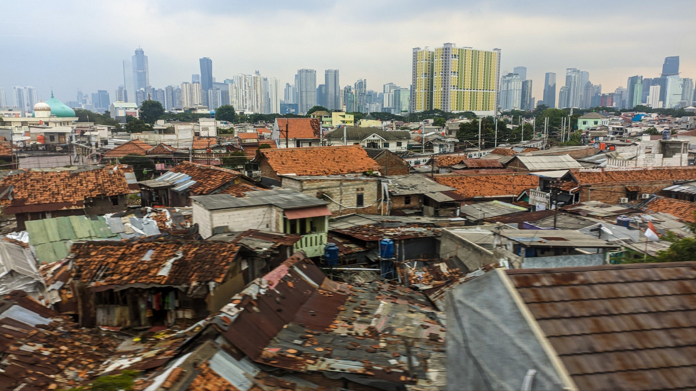 Dense urban housing with modern skyscrapers in the background, highlighting social and economic contrast, Jakarta, Indonesia, Dec. 3, 2022. (Shutterstock Photo)