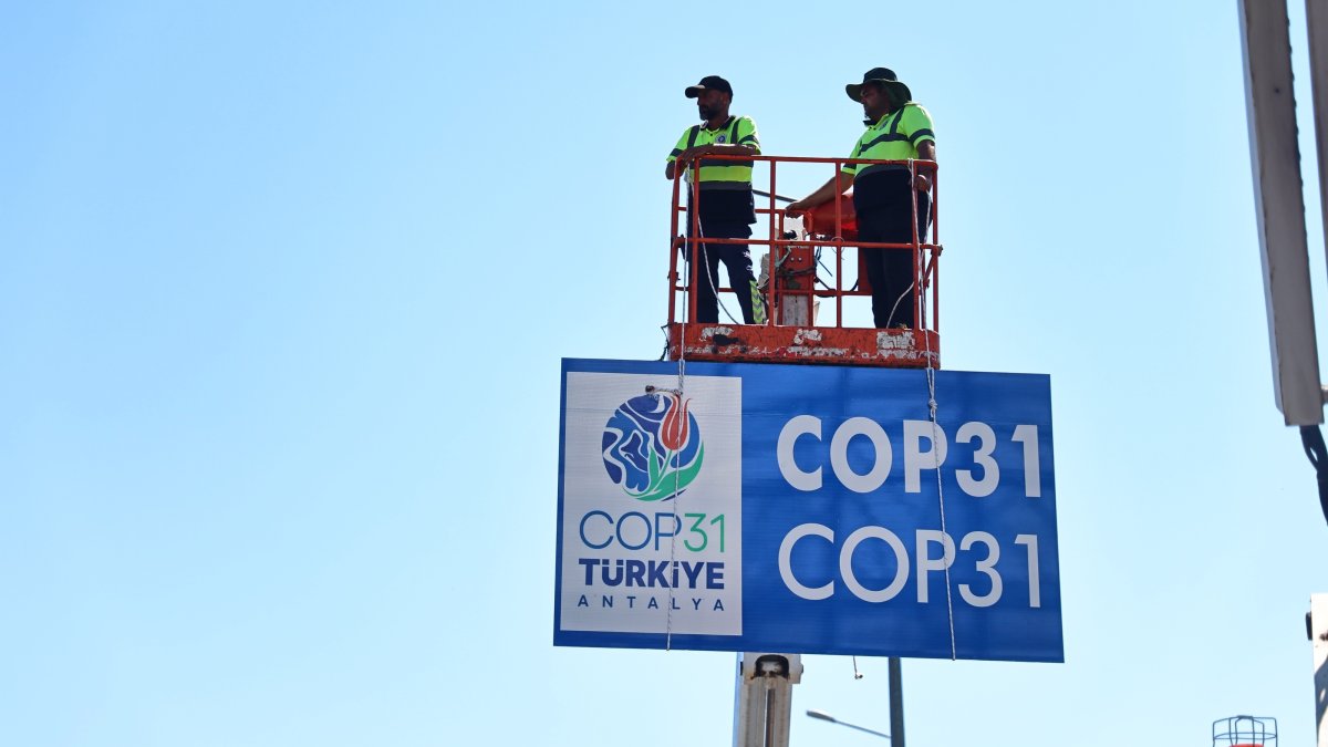 Municipal workers install billboards ahead of the COP31 summit, southern Antalya province, Türkiye, Aug. 25, 2026. (IHA Photo)