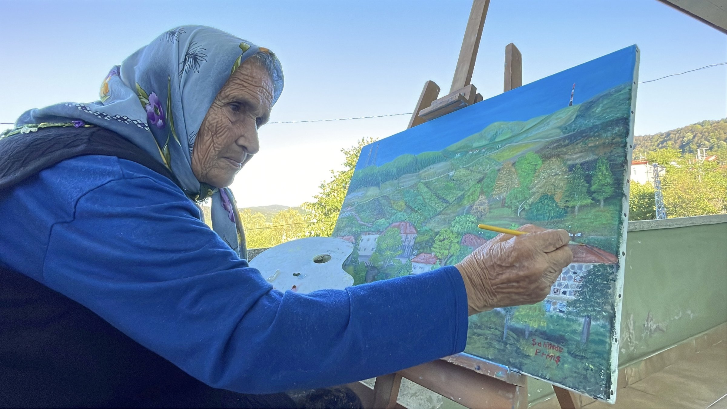 Turkish painter Şahinde Ermiş, 81, works on one of her oil paintings, Zonguldak, Türkiye, Sept. 4, 2026. (DHA Photo)