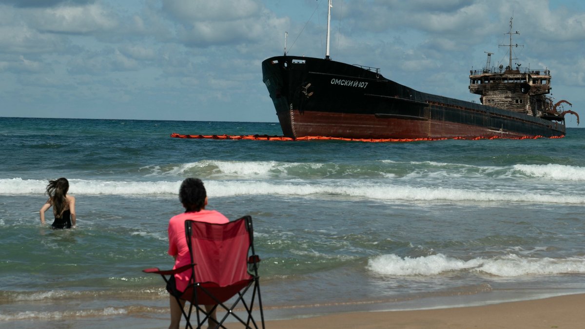 People swim next to the Russian-flagged cargo ship “OMSKIY-107,” which was attacked off the coast of Russia, drifted and ran aground off the shore of Şile, Istanbul, Türkiye, Sept. 3, 2026. (AFP Photo)