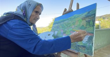 Turkish painter Şahinde Ermiş, 81, works on one of her oil paintings, Zonguldak, Türkiye, Sept. 4, 2026. (DHA Photo)