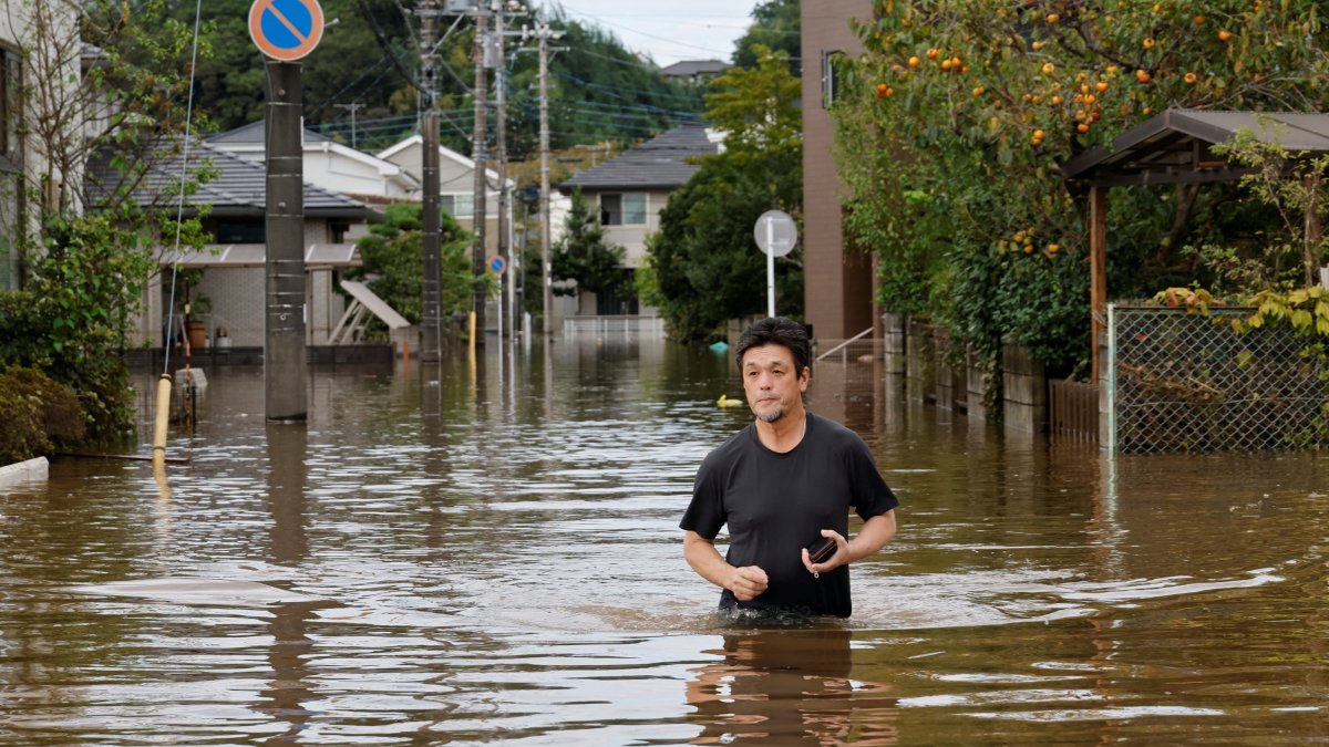 A man wades through a flooded road after Typhoon Dujuan brought torrential rain to Sakura, Chiba prefecture, Japan, Sept. 22, 2026. (Reuters Photo)