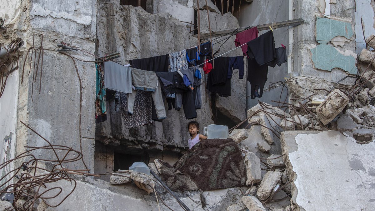 A displaced Palestinian girl stands next to hanging clothes inside a damaged building where she lives with her family in Gaza City, Gaza Strip, Palestine, Sept. 21, 2026. (EPA Photo)