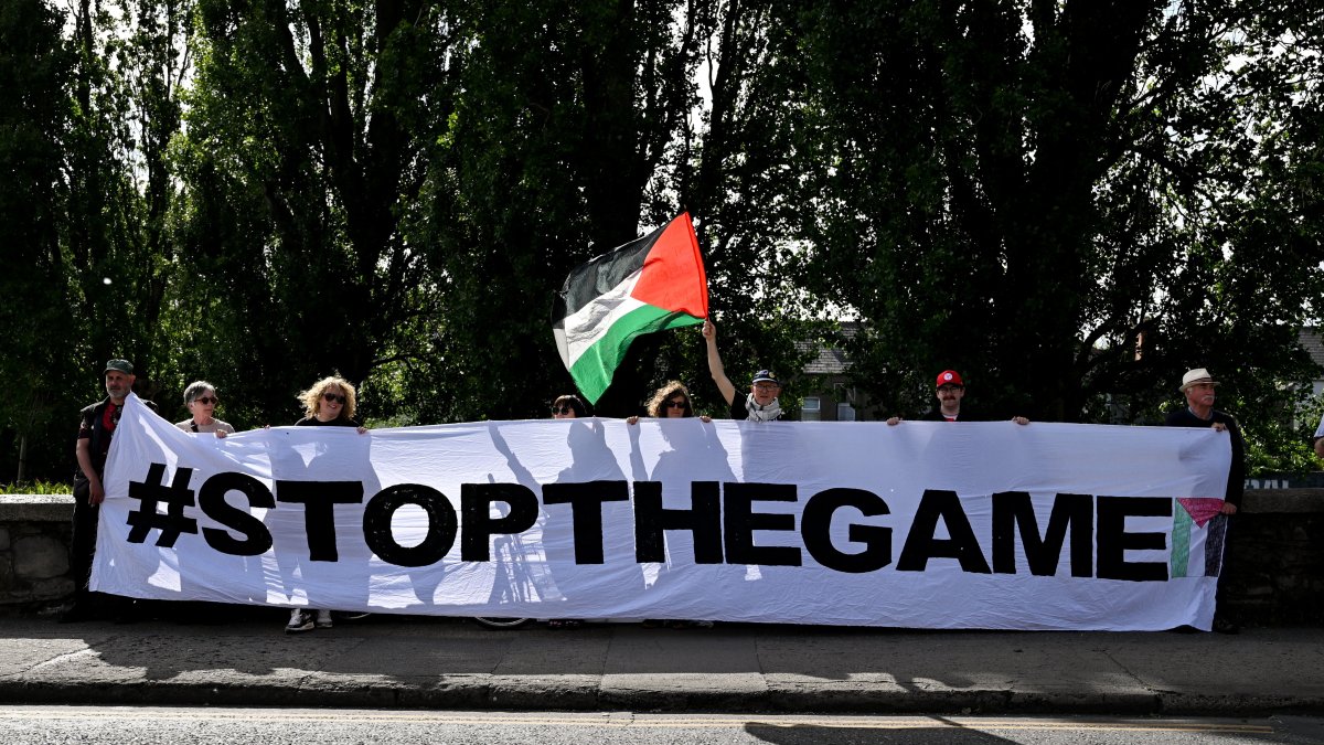 Protestors holding a 'Stop The Game' banner at a protest for stopping the Ireland-Israel Nations League game, on Frank Flood bridge, before the SSE Airtricity Men's Premier Division match between Shelbourne and Shamrock Rovers at Tolka Park, Dublin , Ireland, June 12, 2026. (Getty Images Photo) 