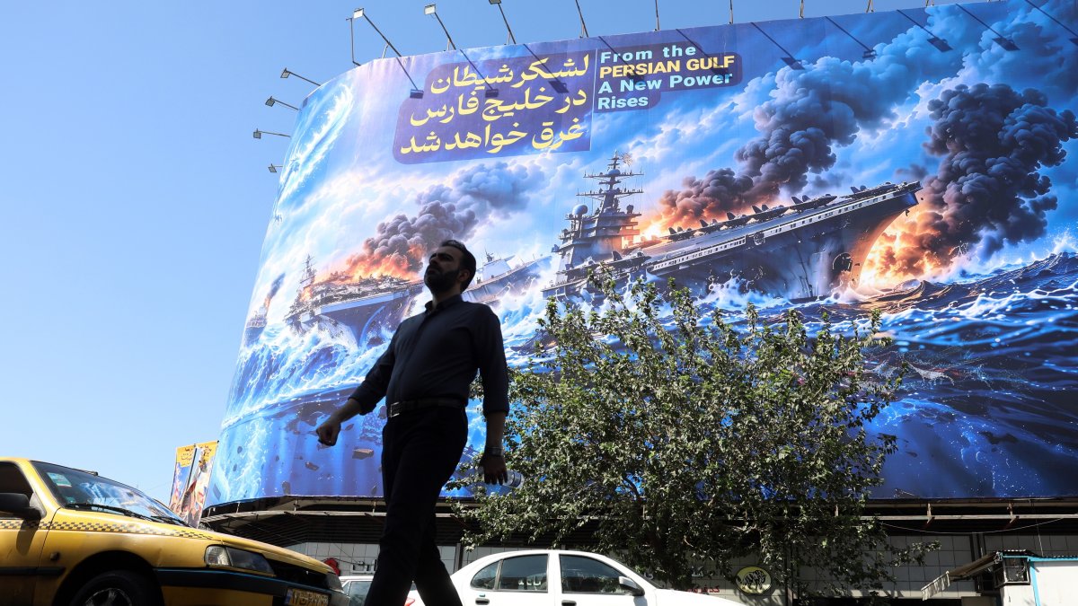 A man walks next to an anti-U.S. billboard carrying a sentence in Persian that reads, "The devil army will be drowned in the Persian Gulf," Tehran, Iran, Sept. 21, 2026. (EPA Photo)