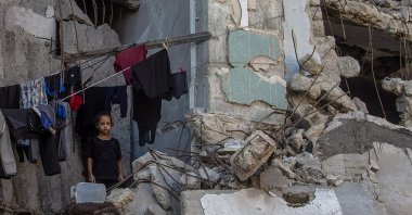 A displaced Palestinian girl stands next to hanging clothes inside a damaged building where she lives with her family, Gaza City, Gaza Strip, Palestine, Sept. 21, 2026. (EPA Photo)
