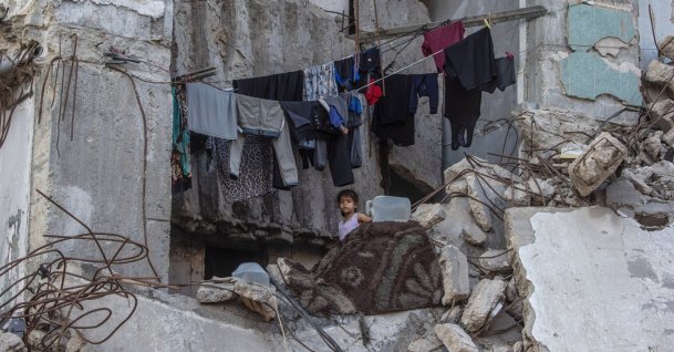 A displaced Palestinian girl stands next to hanging clothes inside a damaged building where she lives with her family in Gaza City, Gaza Strip, Palestine, Sept. 21, 2026. (EPA Photo)