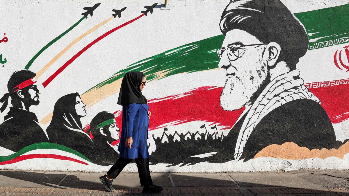An Iranian woman walks past a mural of Iran's assassinated supreme leader, Ayatollah Ali Khamenei, Tehran, Iran, Sept. 23, 2026. (AFP Photo)
