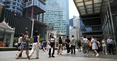 People walk out during lunch time at the financial business district of Raffles Place in Singapore, Sept. 9, 2026. (AFP Photo)