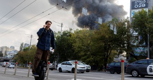 A man rides past a building that caught fire after being struck by a Russian drone, amid Russia's attack on Ukraine in Kyiv, Ukraine, Sept. 23, 2026. (Reuters Photo)