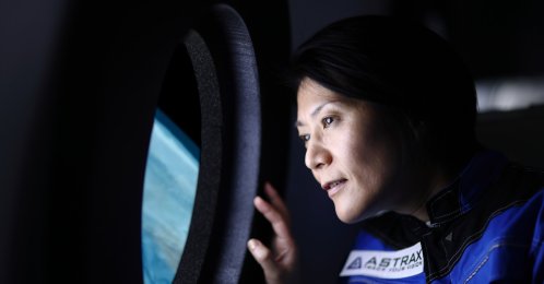 A commercial space traveler looking at the Earth through the window of a spaceship. (Getty Images Photo)
