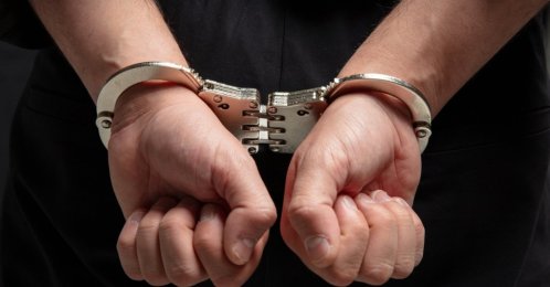 A close-up of a suspect in handcuffs following an arrest. (Shutterstock Photo)