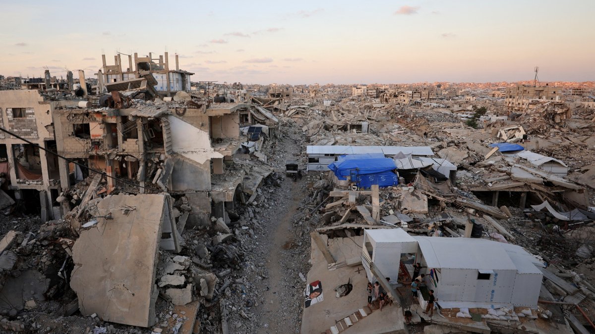 Palestinians stand in front of a tent erected amid the rubble of residential buildings destroyed during the Israeli genocidal military campaign in Gaza City, Sept. 22, 2026. (Reuters Photo)
