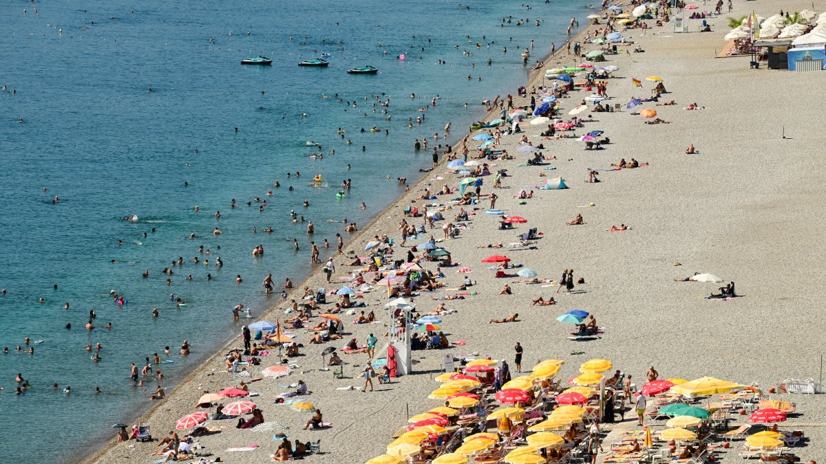 Tourists and residents cool off in the sea at Konyaaltı Beach as temperatures reach 33 degrees Celsius and seawater temperatures climb to 29 degrees amid hot weather,  Antalya, Türkiye, Sept. 19, 2026. (AA Photo)
