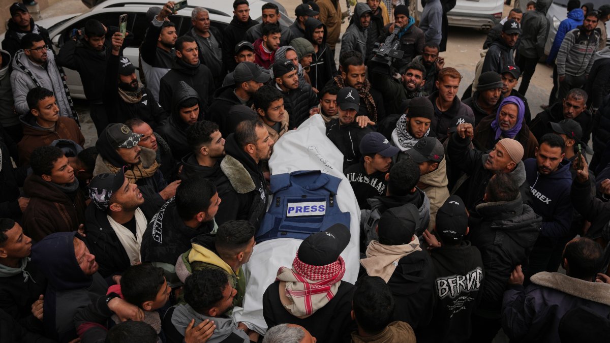 Mourners carry the body of Anas Ghoneim, one of the three Palestinian journalists who were killed in an Israeli strike on an Egyptian committee's vehicle, during his funeral in Khan Younis, Gaza Strip, Palestine, Jan. 22, 2026. (AP Photo)
