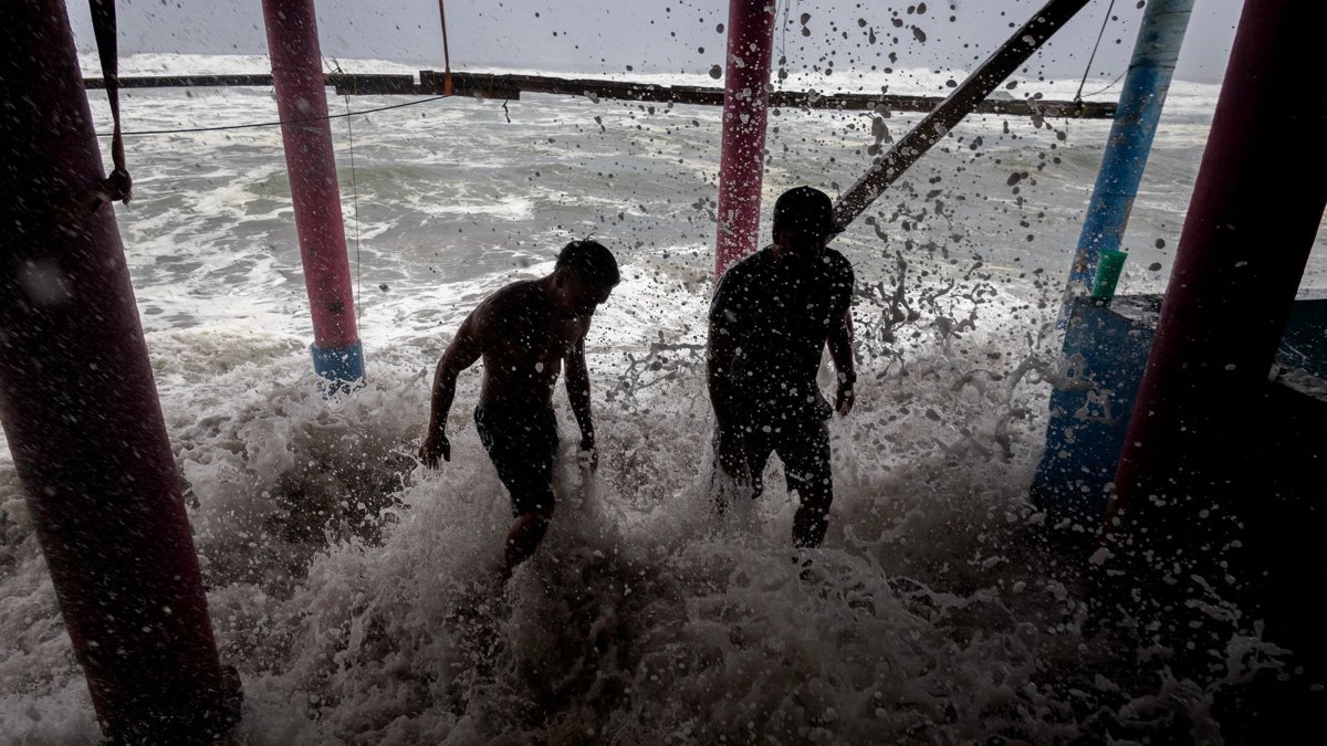 Residents place sandbags as a protective barrier against strong waves at Playa Azul, in the municipality of Lazaro Cardenas, Michoacan, Mexico, Sept. 23, 2026. (AFP Photo)