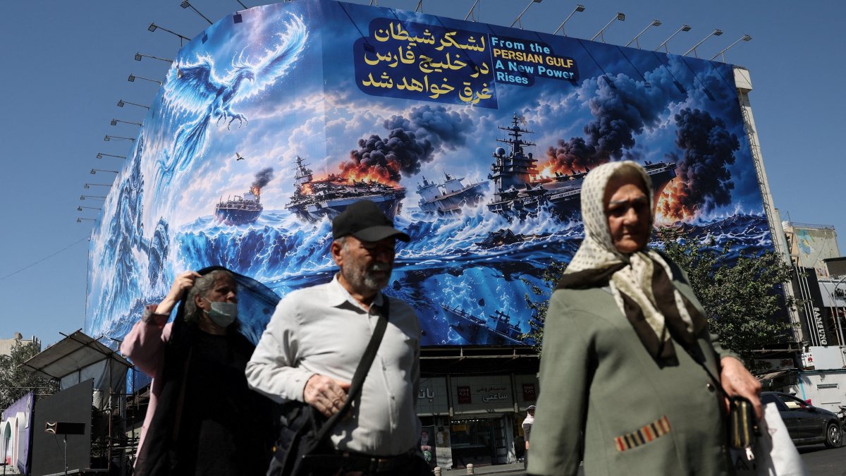 People walk past a billboard about the Strait of Hormuz on a building, Tehran, Iran, Sept. 16, 2026. (Reuters Photo)