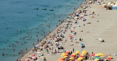 Tourists and residents cool off in the sea at Konyaaltı Beach as temperatures reach 33 degrees Celsius and seawater temperatures climb to 29 degrees amid hot weather,  Antalya, Türkiye, Sept. 19, 2026. (AA Photo)
