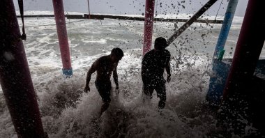 Residents place sandbags as a protective barrier against strong waves at Playa Azul, in the municipality of Lazaro Cardenas, Michoacan, Mexico, Sept. 23, 2026. (AFP Photo)
