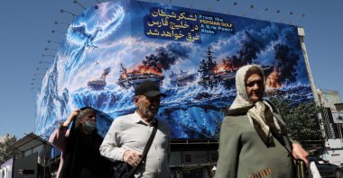 People walk past a billboard about the Strait of Hormuz on a building, Tehran, Iran, Sept. 16, 2026. (Reuters Photo)
