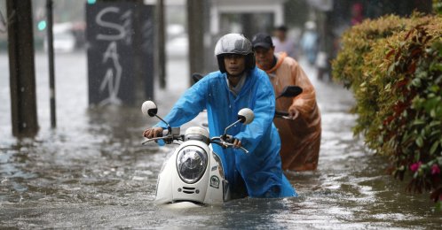 Motorists push their motorbikes through floodwater during a downpour along Phetchaburi Road, Bangkok, Thailand, Sept. 26, 2026. (EPA Photo)
