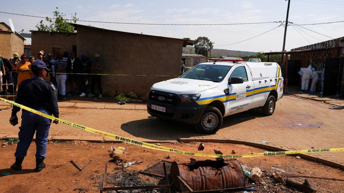 Blood stains on the ground next to an emergency vehicle at the site of a deadly shooting at a tavern in Wedela township, southwest of Johannesburg, South Africa, Sept. 27, 2026. (Reuters Photo)