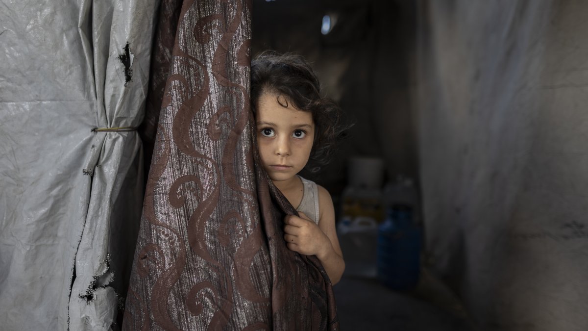 A child looks from behind curtain at a shelter for Gaza's war displaced people, Jabalya, Gaza, Sept. 26, 2026. (AA Photo)