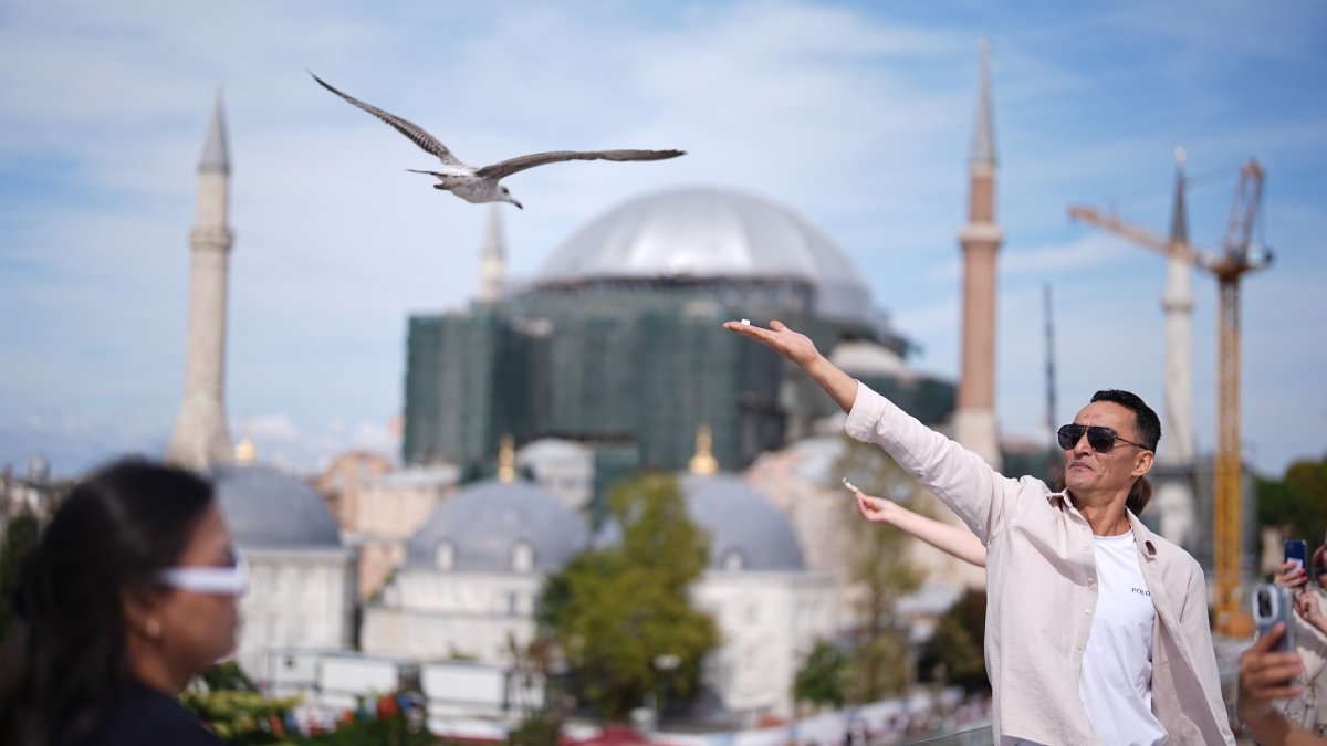 A tourist feeds a seagull on a rooftop close to the popular Sultanahmet Square, Istanbul, Türkiye, Sept. 26, 2026. (AA Photo)