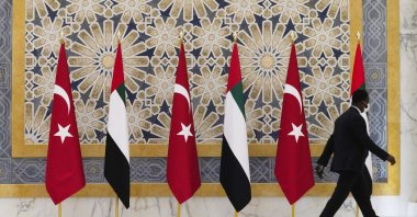 An official walks past Turkish and Emirati flags at Qasr al-Watan, Abu Dhabi, UAE, Feb. 14, 2022. (AP Photo)