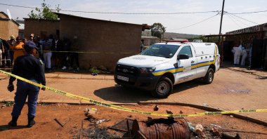 Blood stains on the ground next to an emergency vehicle at the site of a deadly shooting at a tavern in Wedela township, southwest of Johannesburg, South Africa, Sept. 27, 2026. (Reuters Photo)