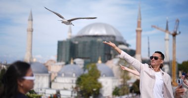A tourist feeds a seagull on a rooftop close to the popular Sultanahmet Square, Istanbul, Türkiye, Sept. 26, 2026. (AA Photo)