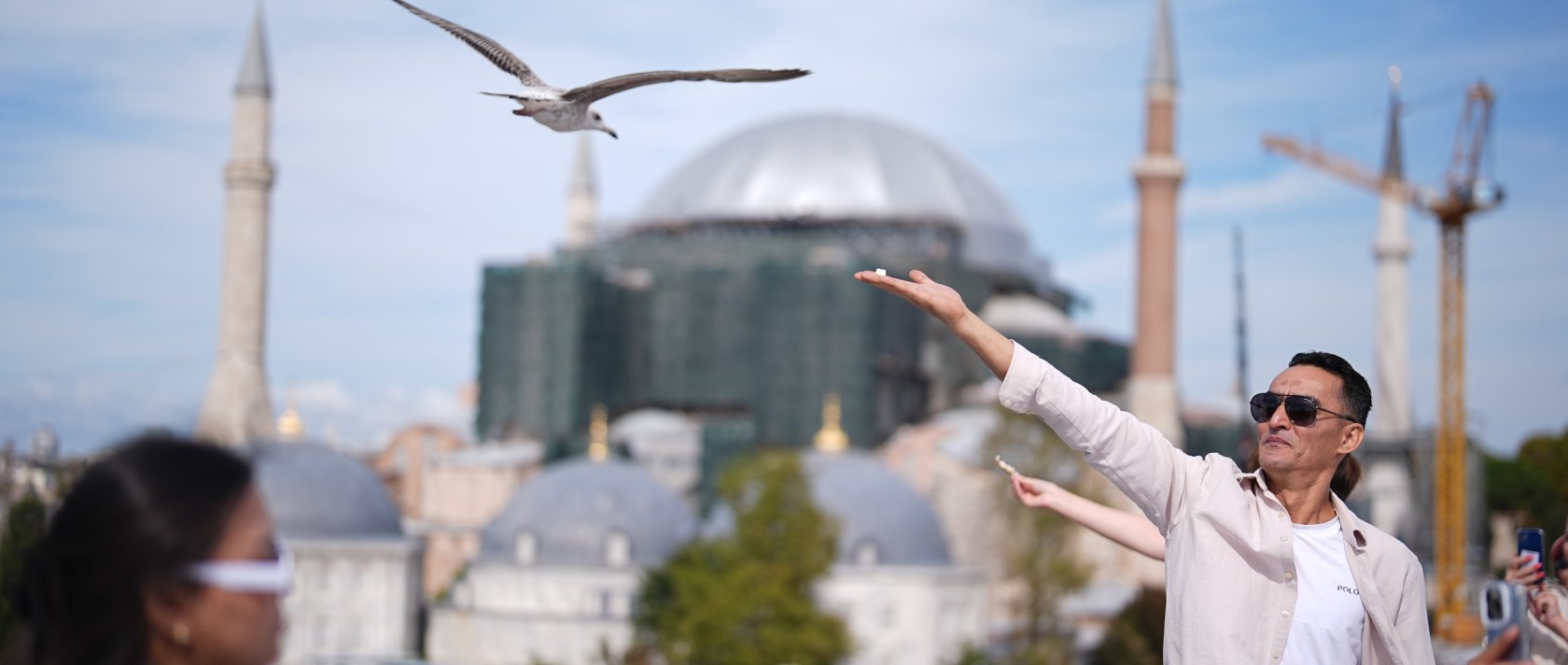 A tourist feeds a seagull on a rooftop close to the popular Sultanahmet Square, Istanbul, Türkiye, Sept. 26, 2026. (AA Photo)