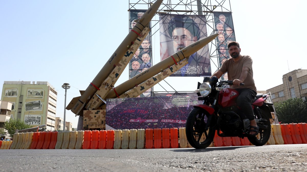 A man drives past Iranian Zolfaghar missiles placed in front of a billboard carrying a picture of Iranian Supreme Leader Ayatollah Mojtaba Khamenei at Baharestan Square in downtown Tehran, Iran, Sept. 28, 2026. (EPA Photo)