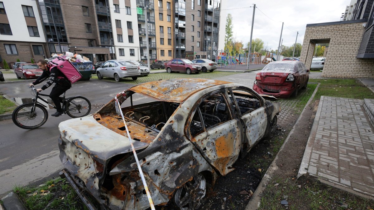 A courier rides a bicycle past a car that was burned in a Ukrainian attack during the Russia-Ukraine conflict, in Yaroslavl, Russia, Sept. 11, 2026. (Reuters File Photo)