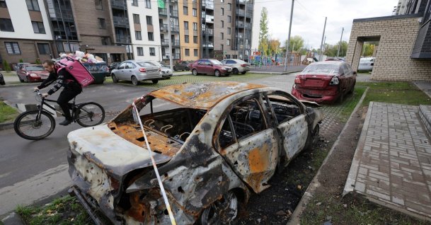 A courier rides a bicycle past a car that was burned in a Ukrainian attack during the Russia-Ukraine conflict, in Yaroslavl, Russia, Sept. 11, 2026. (Reuters File Photo)
